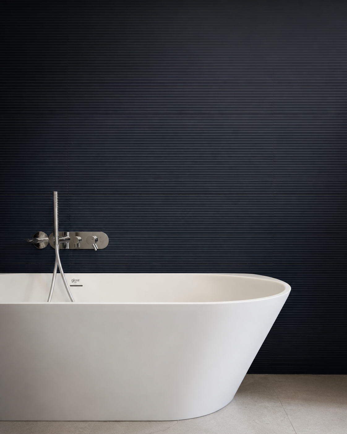Vasca freestanding, rubinetteria e rivestimento blu coordinati in un ambiente bagno